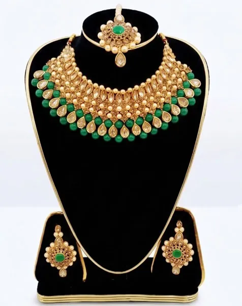 Emerald Elegance Kundan Choker Set includes a statement choker matching drop earrings, and a coordinated maang tikka.
